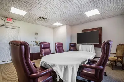 a conference room with a table and leather chairs at Quality Inn & Suites Albany Airport in Latham
