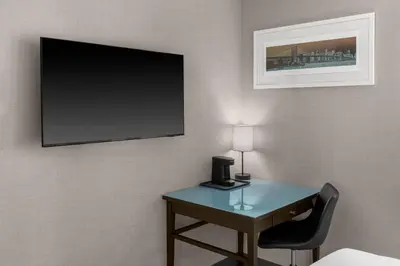 a room with a desk with a television and a chair at Solita Soho Hotel in New York