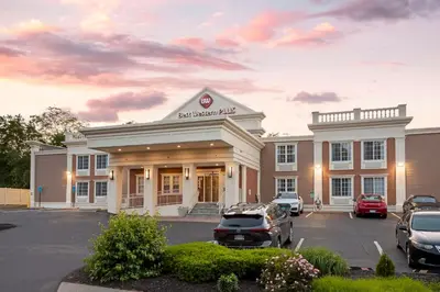 a building with a car parked in a parking lot at Best Western Plus Fairfield Hotel in Fairfield