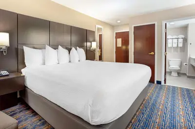 a hotel room with a large bed and a bathroom at Best Western Plus Fairfield Hotel in Fairfield