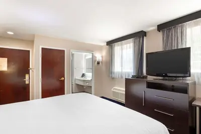 a hotel room with a bed and a flat screen tv at Best Western Plus Fairfield Hotel in Fairfield
