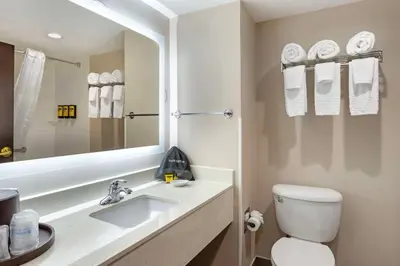 a bathroom with a sink and a toilet and a mirror at Best Western Plus Fairfield Hotel in Fairfield