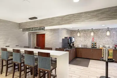 a kitchen and dining room with a bar with chairs at Best Western Plus Fairfield Hotel in Fairfield