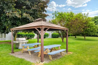 a wooden gazebo with benches in a yard at Best Western Hartford Hotel and Suites in Hartford