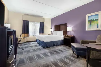 a hotel room with a bed and a chair at Best Western Hartford Hotel and Suites in Hartford