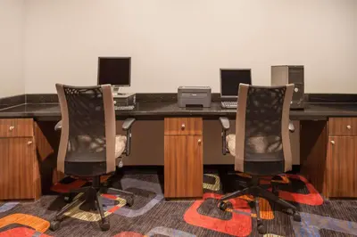 an office with two chairs and a desk with a computer at Days Inn by Wyndham Woodbury Long Island in Woodbury