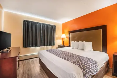 a hotel room with a bed and a flat screen tv at Econo Lodge Inn & Suites Windsor Locks Bradley Airport in Windsor Locks