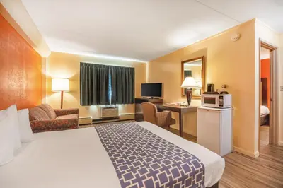 a hotel room with a bed and a living room at Econo Lodge Inn & Suites Windsor Locks Bradley Airport in Windsor Locks