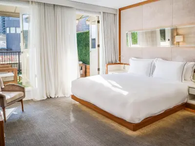 a bedroom with a large white bed and a chair at 33 Hotel, New York City, Seaport in New York