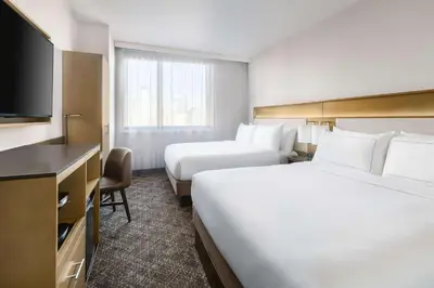 a hotel room with two beds and a flat screen tv at DoubleTree by Hilton New York Times Square South in New York