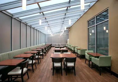 a row of tables and chairs in a room with windows at Holiday Inn Manhattan 6th Ave - Chelsea by IHG in New York