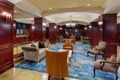 a lobby with couches and chairs on a blue rug at Omni New Haven Hotel at Yale in New Haven