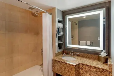 a bathroom with a sink and a tub and a mirror at Omni New Haven Hotel at Yale in New Haven