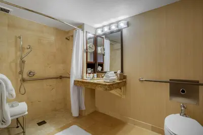 a bathroom with a shower and a toilet and a sink at Omni New Haven Hotel at Yale in New Haven