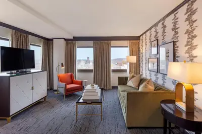 a living room with a couch and a tv at Omni New Haven Hotel at Yale in New Haven