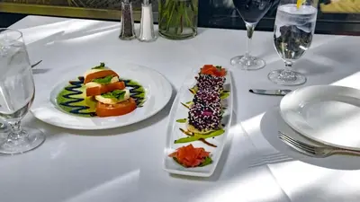 a white table with two plates of food on it at Ethan Allen Hotel in Danbury