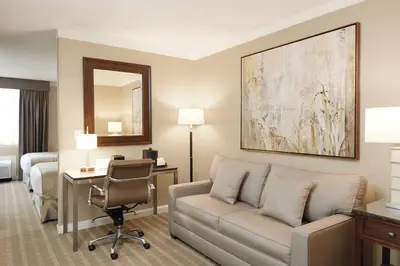 a hotel room with a couch and a desk and a bed at Ethan Allen Hotel in Danbury