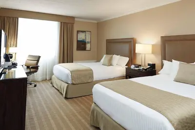a hotel room with two beds and a television at Ethan Allen Hotel in Danbury