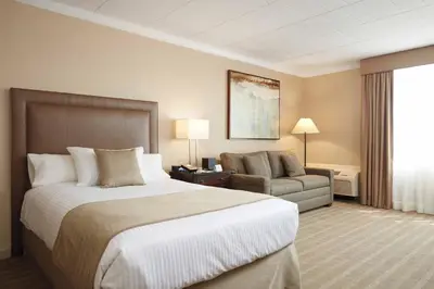 a hotel room with a large bed and a chair at Ethan Allen Hotel in Danbury