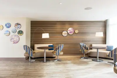 a restaurant with tables and chairs and plates on the wall at EVEN Hotel Norwalk by IHG in Norwalk