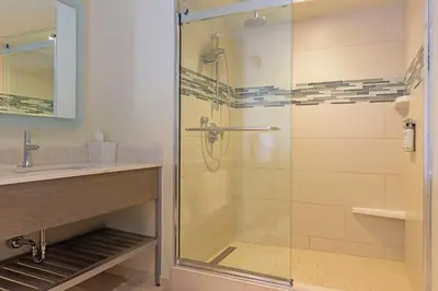 a bathroom with a glass shower with a sink at EVEN Hotel Norwalk by IHG in Norwalk