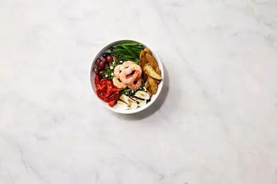a bowl of food with shrimp and vegetables on a counter at EVEN Hotel Norwalk by IHG in Norwalk