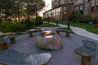 a fire pit in a courtyard with benches and a building at The Abbey Inn & Spa in Peekskill