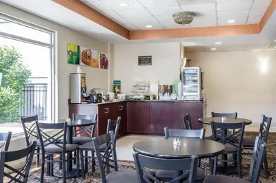 a restaurant with tables and chairs and a refrigerator at Quality Inn & Suites Danbury near University in Danbury