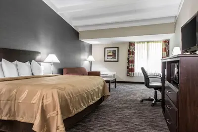 a hotel room with a bed and a desk at Quality Inn & Suites Danbury near University in Danbury