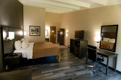 a hotel room with a bed and a desk and a television at Quality Inn & Suites Danbury near University in Danbury