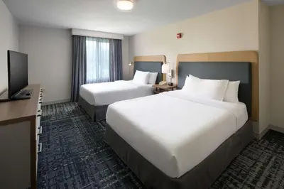 a hotel room with two beds and a flat screen tv at Homewood Suites by Hilton Newburgh-Stewart Airport in New Windsor