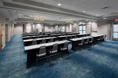 a conference room with chairs and tables and a screen at Homewood Suites by Hilton Newburgh-Stewart Airport in New Windsor