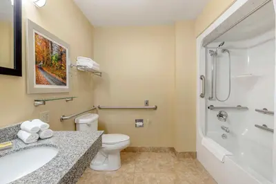 a bathroom with a toilet and a sink and a shower at Best Western Plus New England Inn & Suites in Berlin