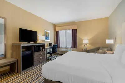 a hotel room with a bed and a flat screen tv at Best Western Plus New England Inn & Suites in Berlin