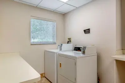 a room with a washer and dryer next to a window at Best Western Plus New England Inn & Suites in Berlin