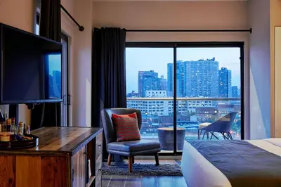 a hotel room with a bed and a large window at Ravel Hotel Trademark Collection by Wyndham in Queens