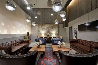 a lobby with leather couches and a table and chairs at Ravel Hotel Trademark Collection by Wyndham in Queens