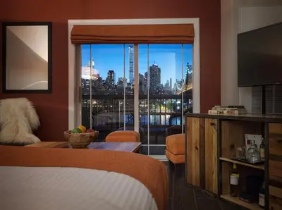 a bedroom with a large window with a view of a city at Ravel Hotel Trademark Collection by Wyndham in Queens