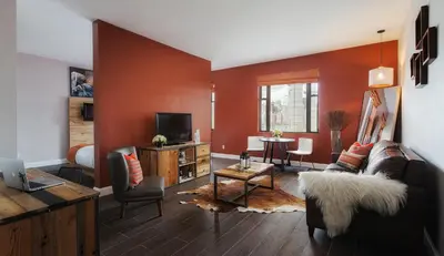 a living room with a couch and a tv at Ravel Hotel Trademark Collection by Wyndham in Queens