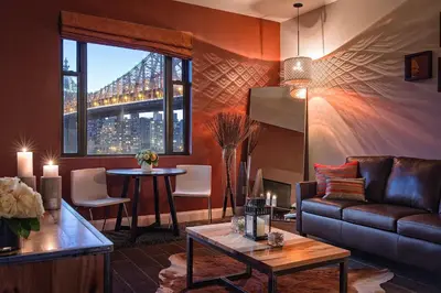 a living room with a couch and a table at Ravel Hotel Trademark Collection by Wyndham in Queens