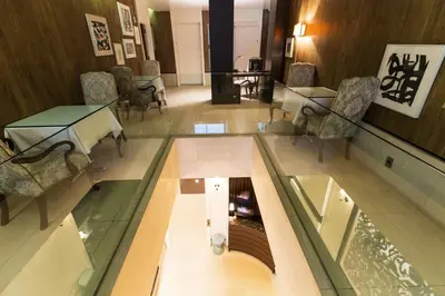 a lobby with a glass floor and chairs and tables at City Club Hotel in New York