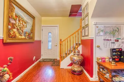 a hallway with red and yellow walls and a vase at Mountain Treasure Bed and Breakfast in Maplecrest