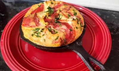 a pizza on a red plate with a spatula at Mountain Treasure Bed and Breakfast in Maplecrest
