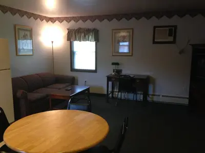 a living room with a table and a couch at Fred's Inn Restaurant & Lodging in Norwich