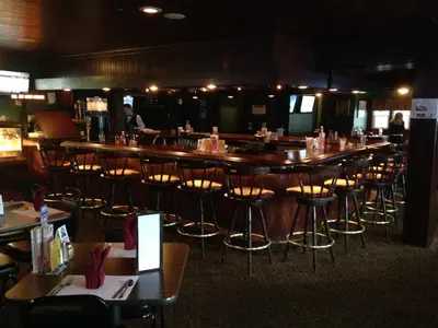 a bar in a restaurant with chairs and tables at Fred's Inn Restaurant & Lodging in Norwich
