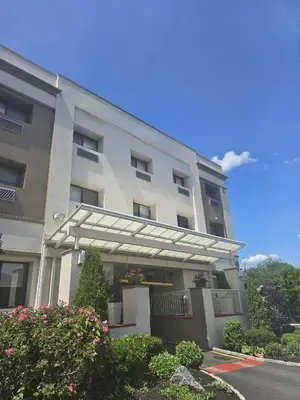 a large white building with awning in front of it at Best Western Roslyn-Long Island Hotel in Roslyn