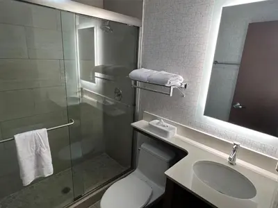 a bathroom with a shower and a toilet and a sink at Best Western Roslyn-Long Island Hotel in Roslyn