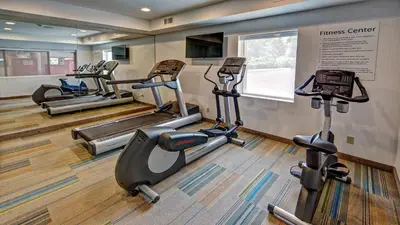 a fitness center with several tread machines in a room at Best Western Roslyn-Long Island Hotel in Roslyn