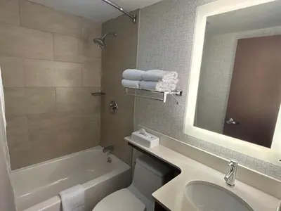 a bathroom with a sink and a tub and a toilet at Best Western Roslyn-Long Island Hotel in Roslyn