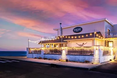 a building with lights in front of the ocean at The Surfside Hotel in Stratford
